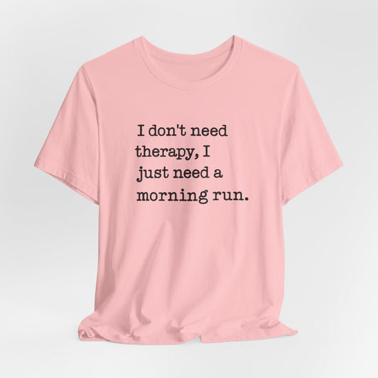 Pink t-shirt with text 'I don't need therapy, I just need a morning run.' on a light gray background