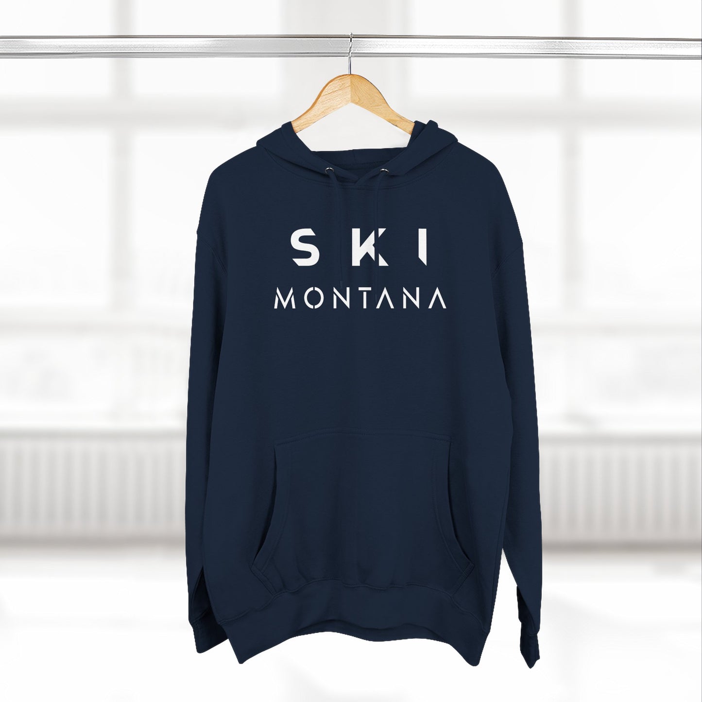 Navy blue hoodie with 'SKI MONTANA' text on a hanger against a white background