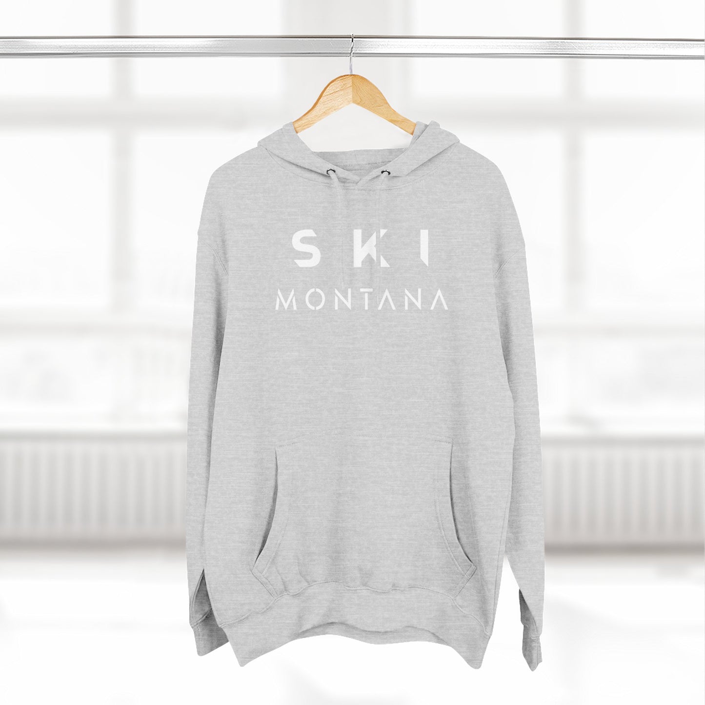 Gray hoodie with 'SKI MONTANA' text on a hanger against a white background