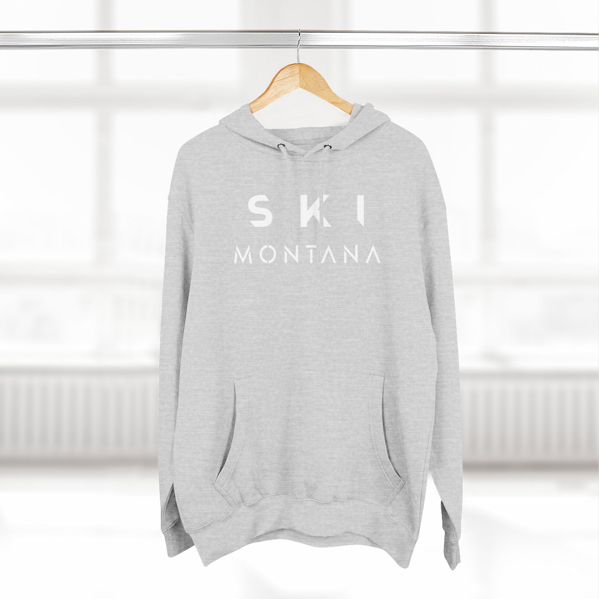 Gray hoodie with 'SKI MONTANA' text on a hanger against a white background