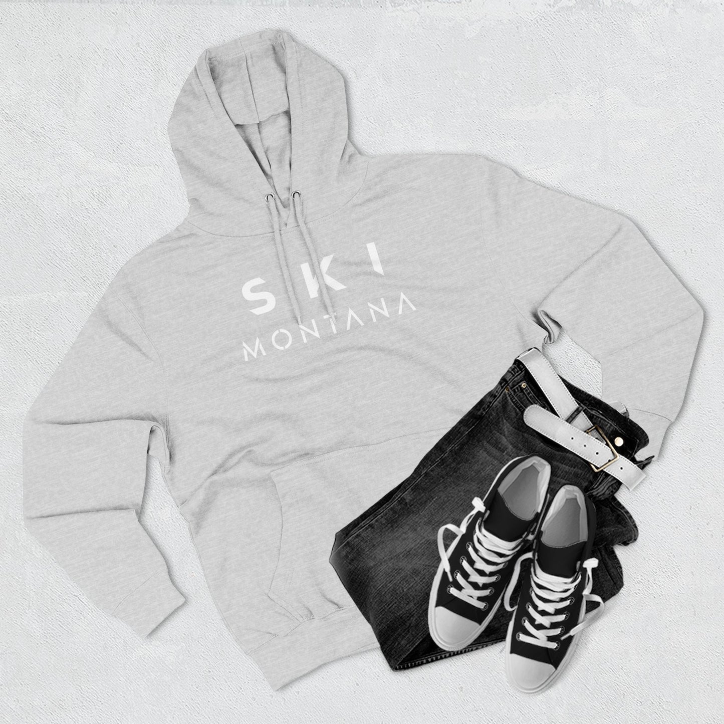 Gray hoodie with 'Ski Montana' text, black jeans, and black sneakers on a light gray background